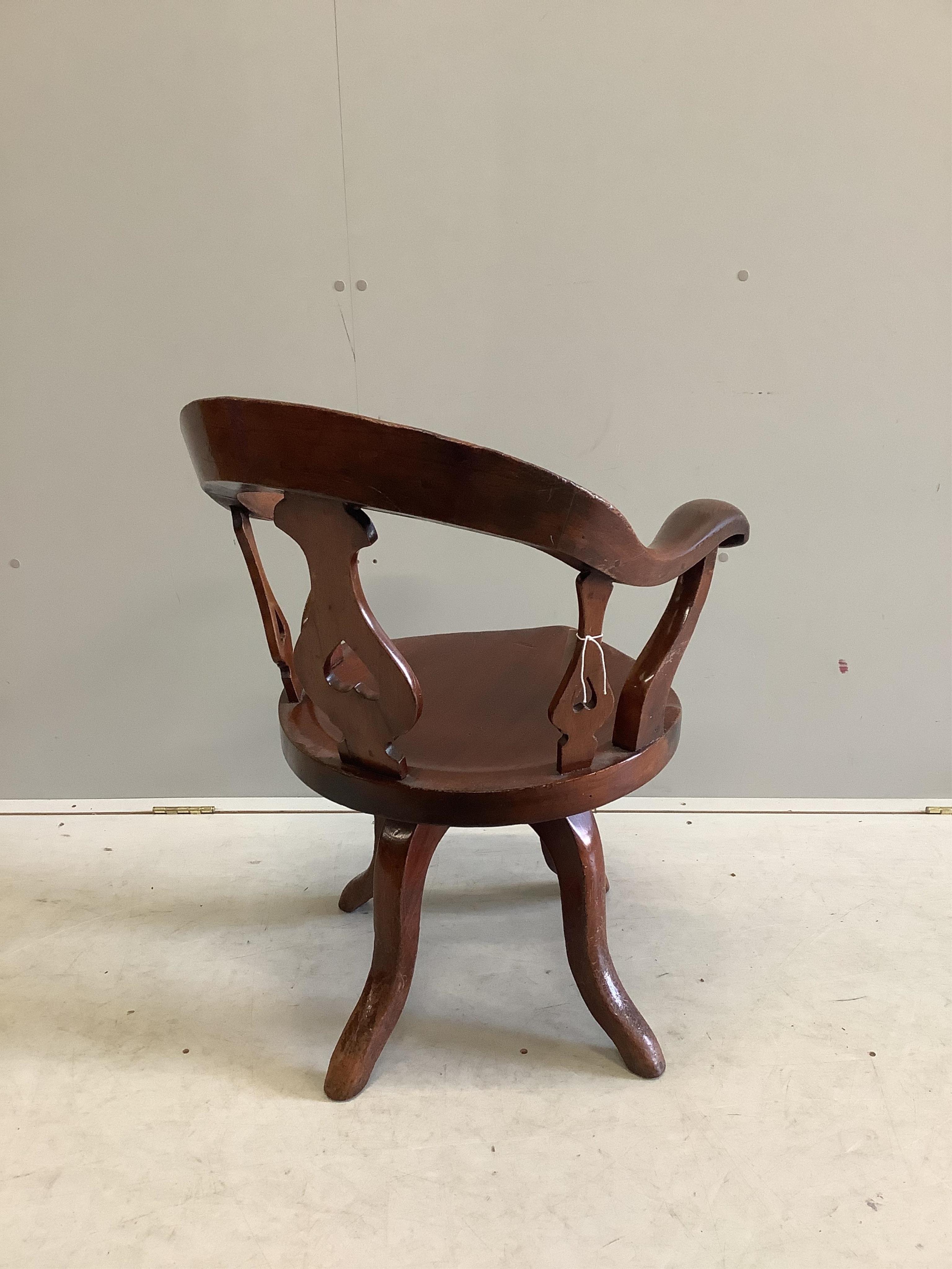 A Victorian mahogany desk chair with scroll arms, on swivel base, width 55cm, depth 50cm, height 88cm. Condition - fair